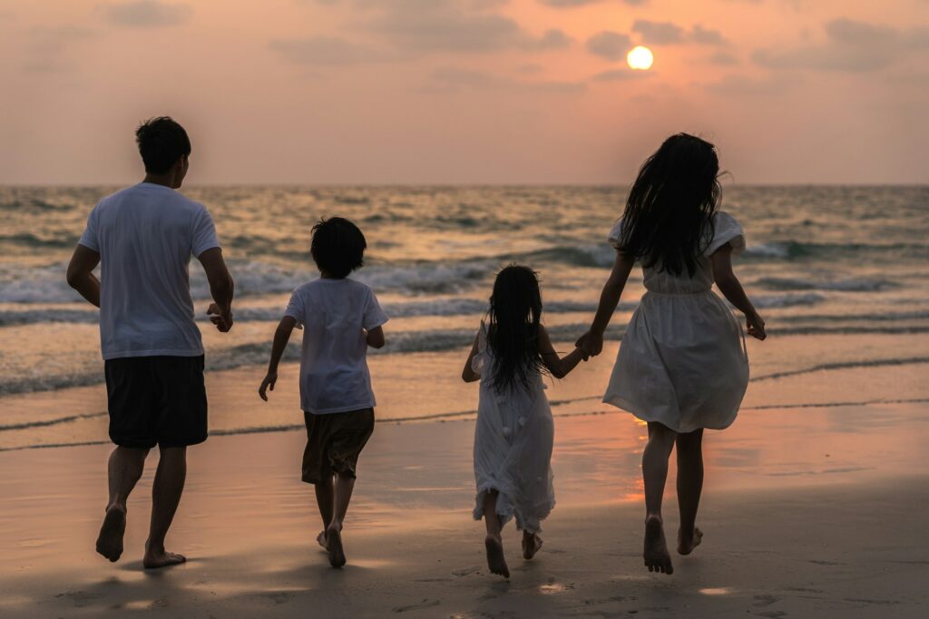 Asian young happy family enjoy vacation on beach in evening.