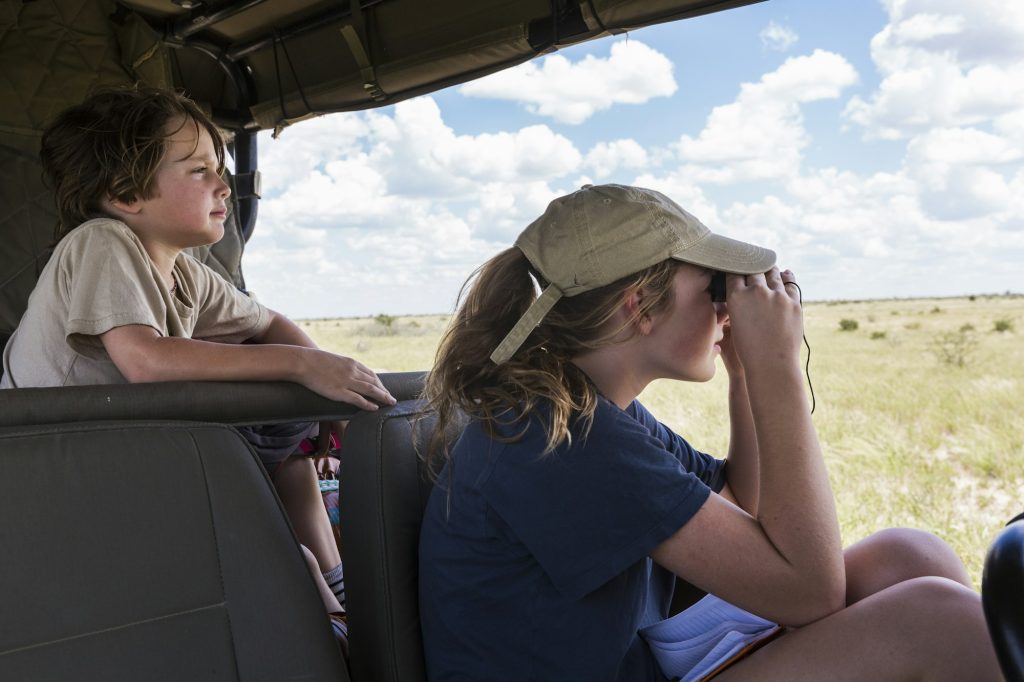 brother and sister in safari vehicle