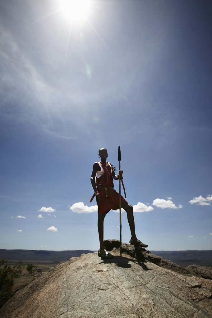 Maasai man standing on top of rock