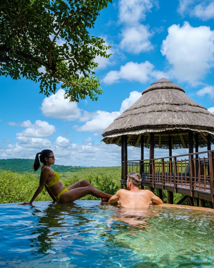 South Africa, luxury safari lodge in the bush of a Game reserve, couple by swimmingpool