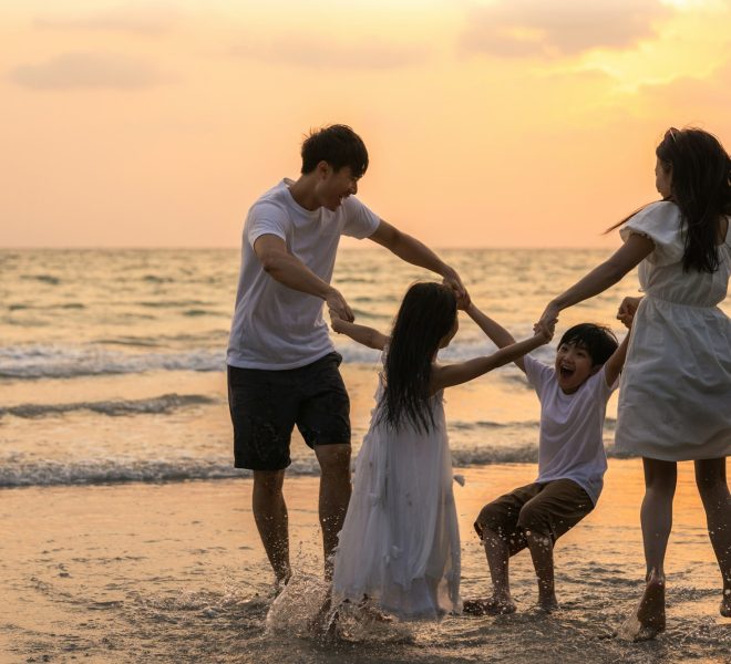 Asian young happy family enjoy vacation on beach in the evening.