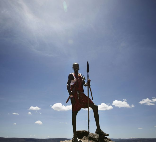 Maasai man standing on top of rock