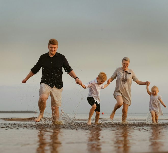 nice caucasian family having fun running in sea on sunset.Summer vacation with kids
